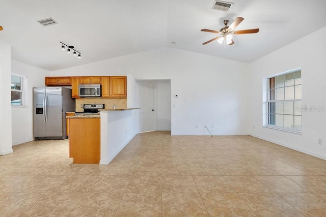 kitchen with ceiling fan, stainless steel appliances, light stone counters, kitchen peninsula, and lofted ceiling