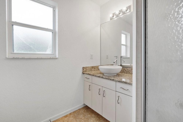 bathroom with plenty of natural light, vanity, and walk in shower