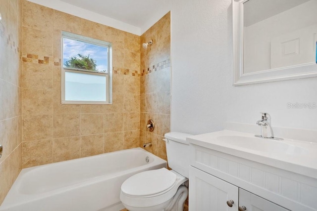 full bathroom featuring vanity, tiled shower / bath combo, and toilet