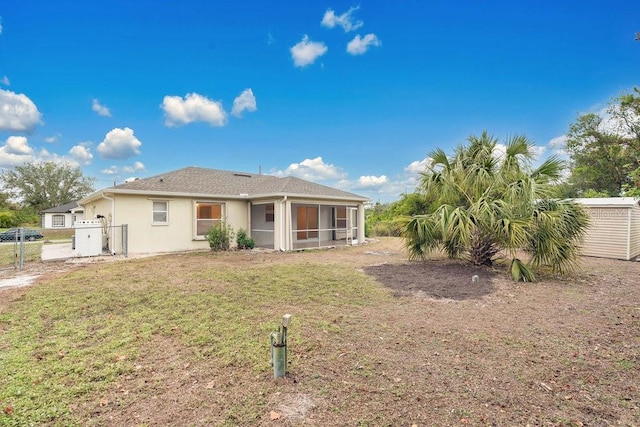 back of house with a sunroom and a yard