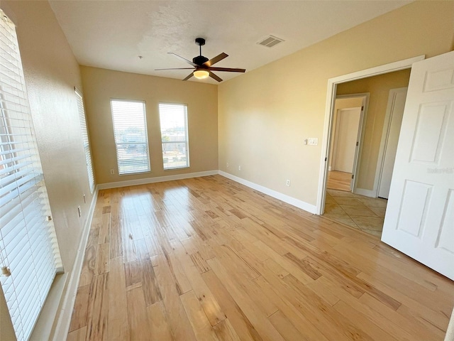 empty room featuring ceiling fan and light hardwood / wood-style flooring