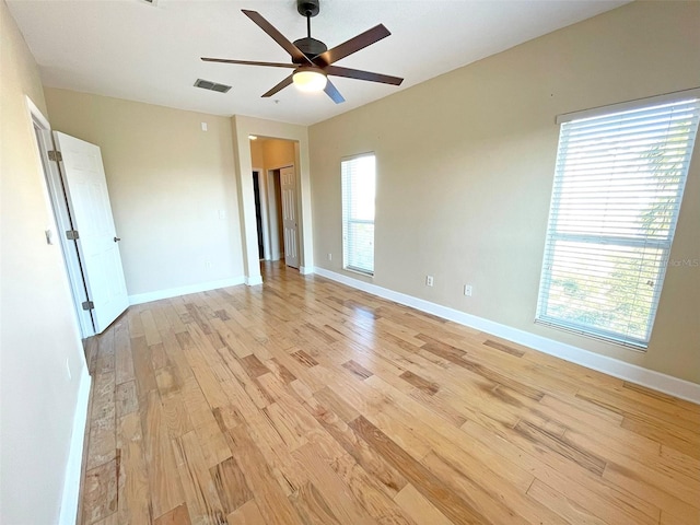 spare room featuring light hardwood / wood-style flooring, a wealth of natural light, and ceiling fan