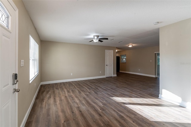 unfurnished living room featuring ceiling fan and dark hardwood / wood-style floors