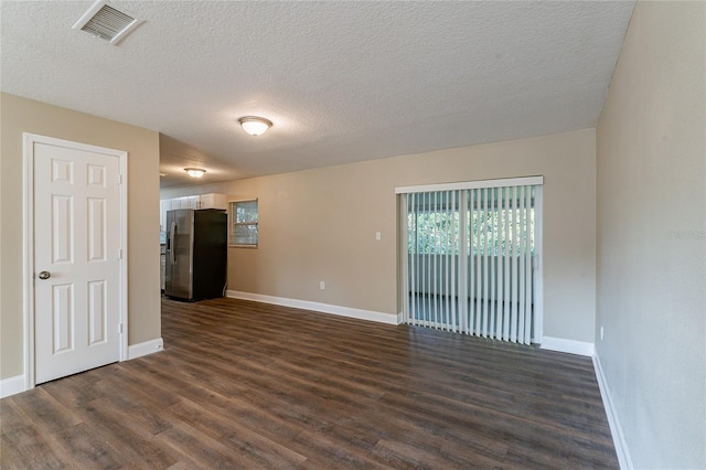 unfurnished living room with a textured ceiling and dark hardwood / wood-style flooring