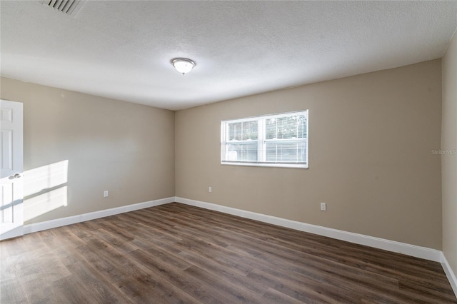 unfurnished room featuring a textured ceiling and dark hardwood / wood-style flooring