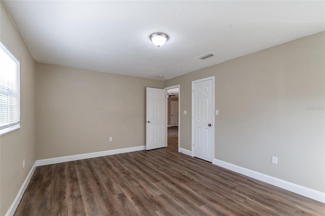 spare room with dark wood-type flooring