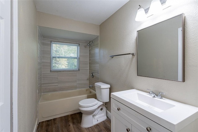 full bathroom featuring toilet, tiled shower / bath combo, hardwood / wood-style floors, and vanity