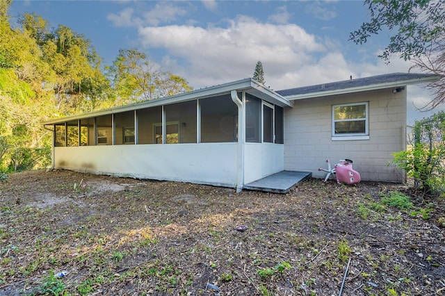 rear view of property featuring a sunroom