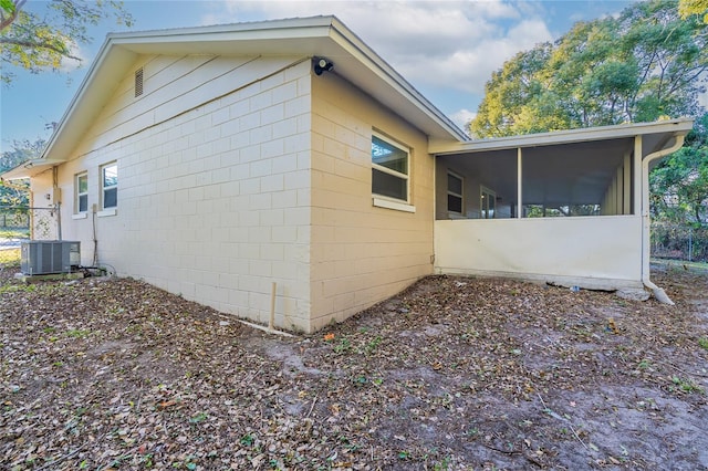 view of side of home with central AC and a sunroom