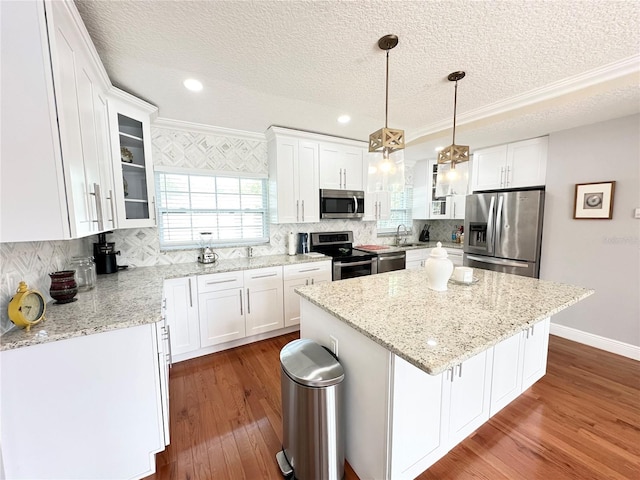 kitchen with white cabinetry, stainless steel appliances, and a kitchen island