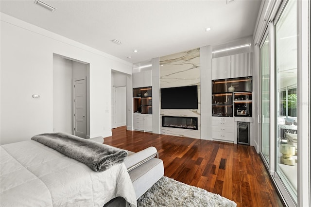 bedroom featuring a premium fireplace and hardwood / wood-style floors