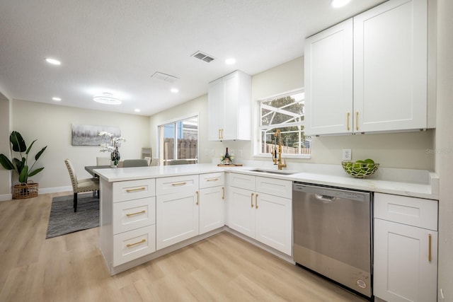 kitchen with stainless steel dishwasher, white cabinets, kitchen peninsula, and light hardwood / wood-style floors