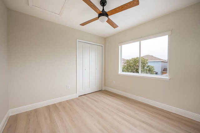 unfurnished bedroom featuring ceiling fan, light wood-type flooring, and a closet