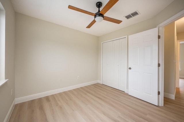 unfurnished bedroom featuring light wood-type flooring, ceiling fan, and a closet