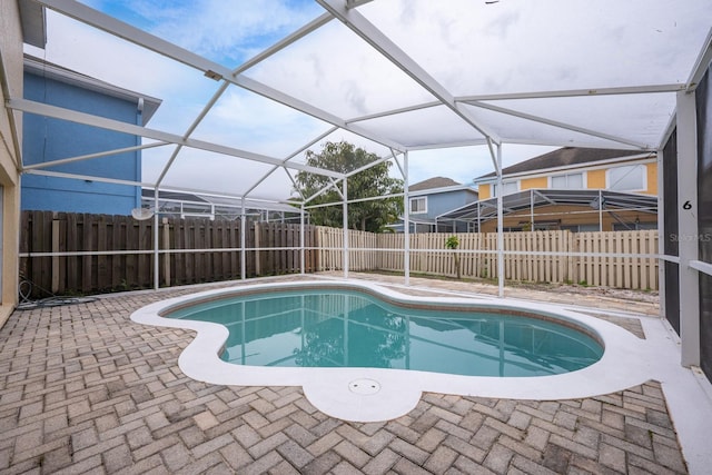 view of pool featuring glass enclosure and a patio area