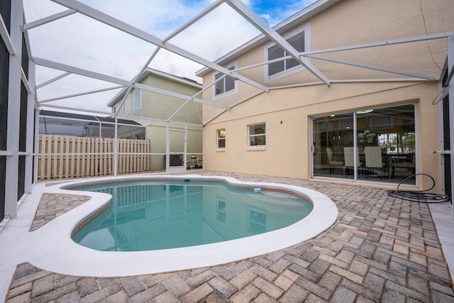 view of swimming pool featuring a patio area and glass enclosure