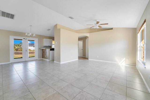 unfurnished living room with french doors, lofted ceiling, ceiling fan with notable chandelier, and light tile patterned floors