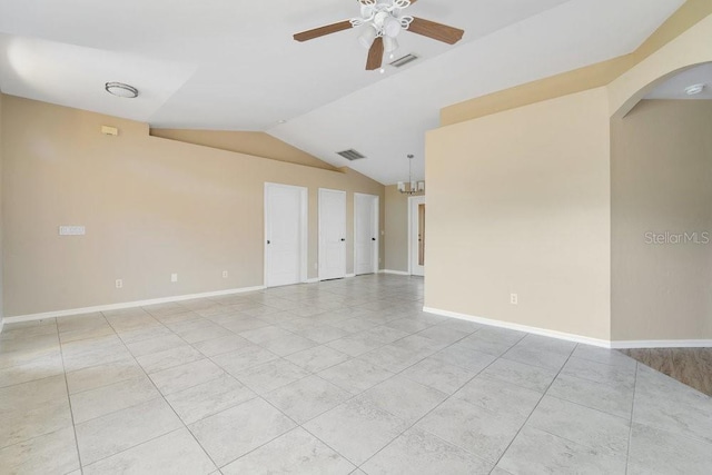 tiled empty room featuring lofted ceiling and ceiling fan with notable chandelier