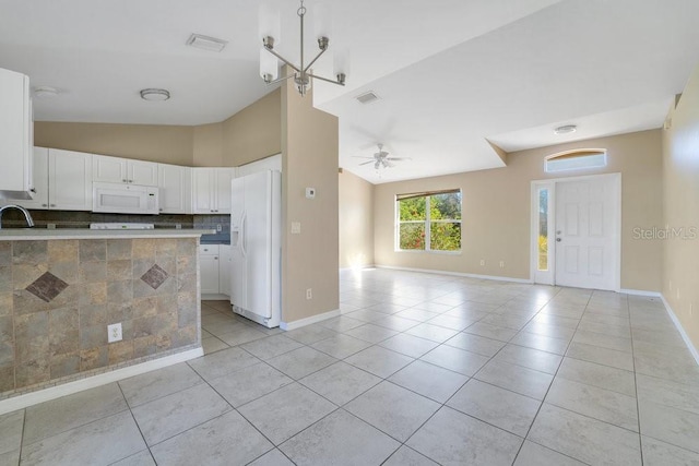 kitchen featuring backsplash, lofted ceiling, white appliances, white cabinets, and ceiling fan with notable chandelier