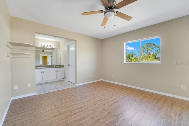 unfurnished bedroom with connected bathroom, ceiling fan, and light wood-type flooring