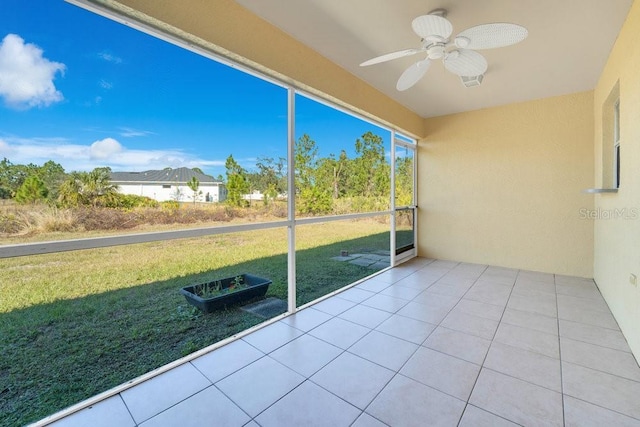 unfurnished sunroom featuring ceiling fan