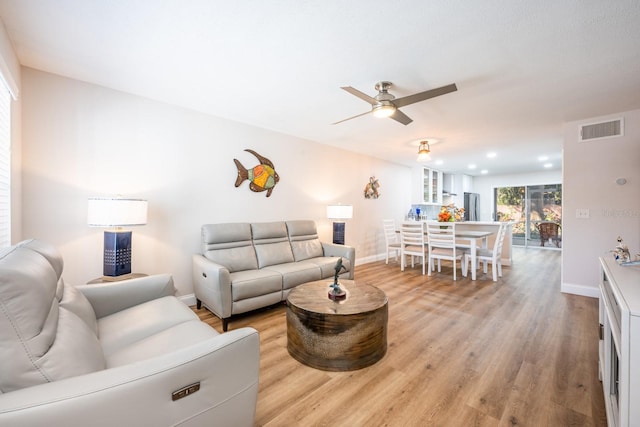 living room with light wood-type flooring and ceiling fan