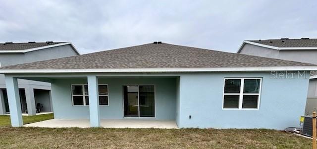 rear view of house featuring a patio, central AC unit, and a lawn