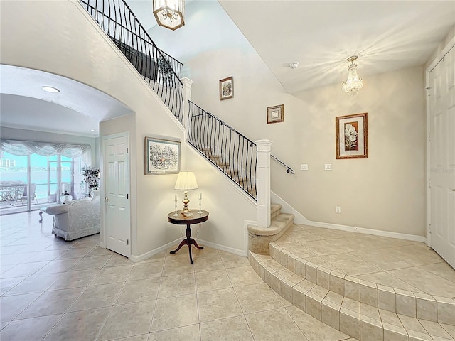 staircase featuring tile patterned flooring and an inviting chandelier