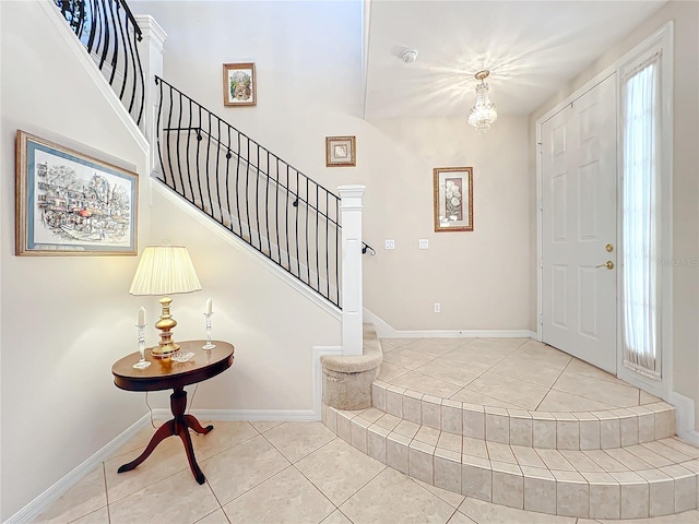 tiled entrance foyer with a notable chandelier