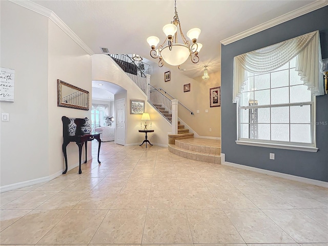 tiled entrance foyer with a chandelier and crown molding