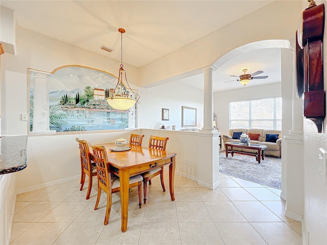 carpeted dining room featuring ornate columns and ceiling fan