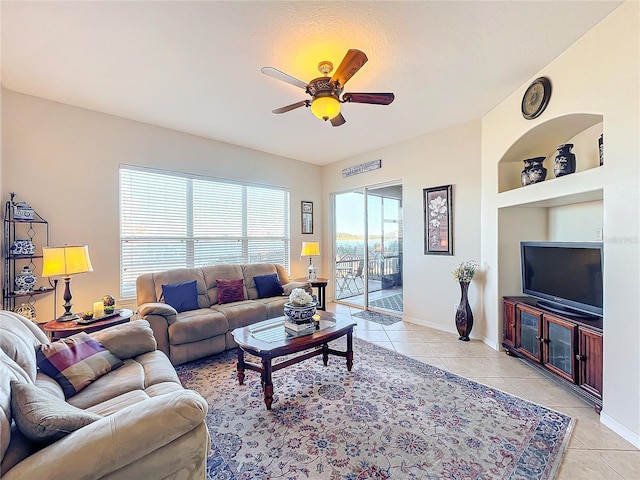 living room with ceiling fan, built in features, and light tile patterned flooring