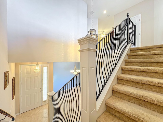 staircase featuring tile patterned flooring and a chandelier