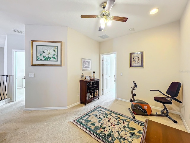 workout area featuring ceiling fan and light colored carpet