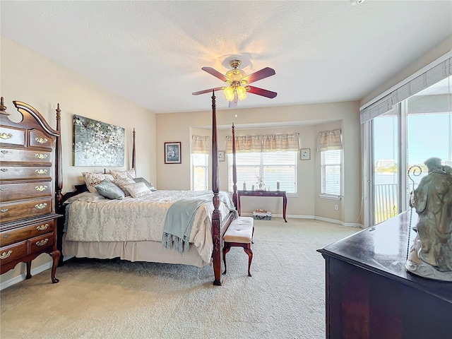 carpeted bedroom featuring access to outside, ceiling fan, and a textured ceiling