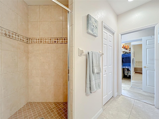 bathroom with a tile shower and tile patterned floors