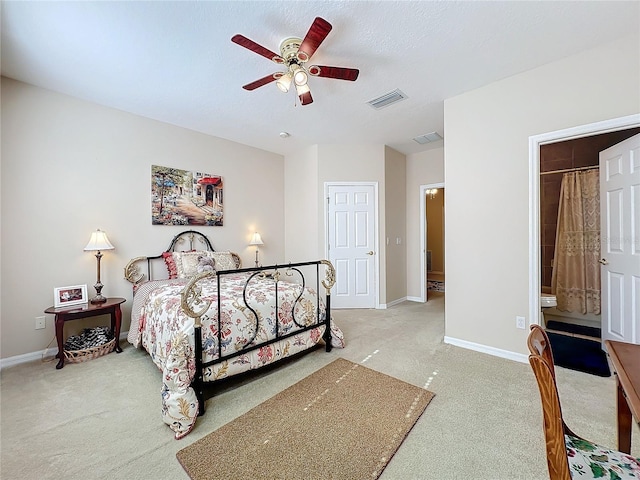 carpeted bedroom featuring ensuite bath and ceiling fan