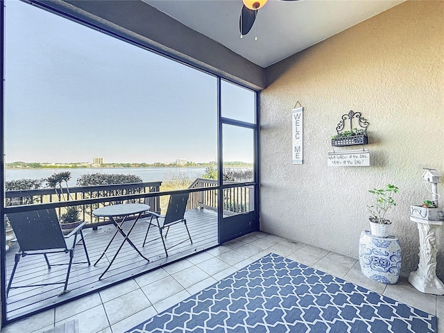 balcony featuring ceiling fan and a water view