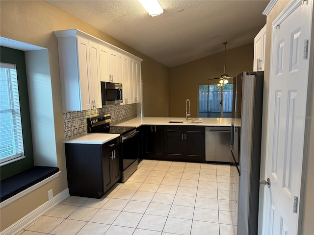 kitchen with vaulted ceiling, stainless steel appliances, white cabinetry, and tasteful backsplash