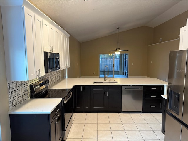 kitchen with white cabinets, sink, appliances with stainless steel finishes, tasteful backsplash, and kitchen peninsula