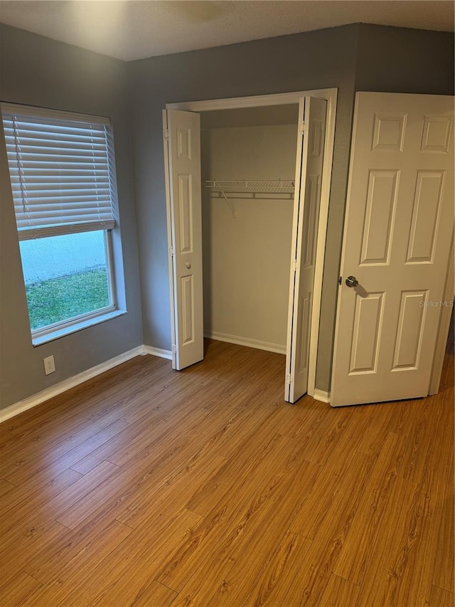 unfurnished bedroom featuring light hardwood / wood-style flooring and a closet