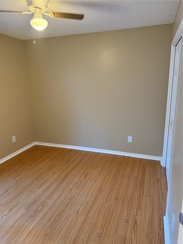 empty room featuring ceiling fan, a textured ceiling, and light wood-type flooring