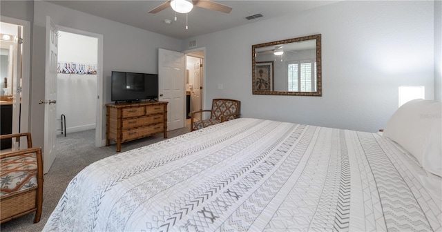 carpeted bedroom with ensuite bathroom and ceiling fan