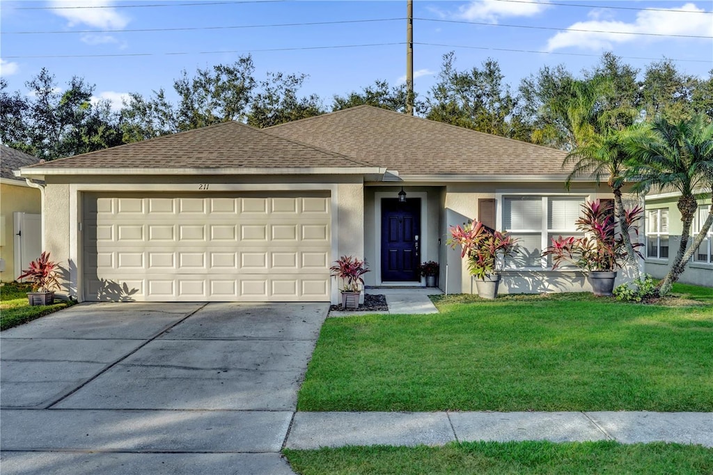 single story home featuring a garage and a front lawn