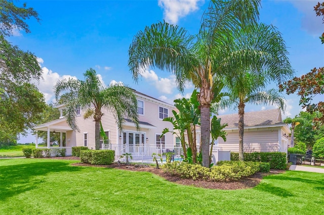 rear view of property featuring a lawn