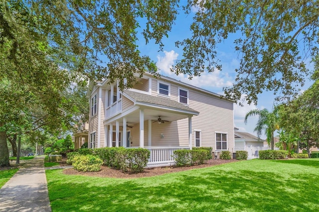 view of front facade with a front yard, ceiling fan, and covered porch