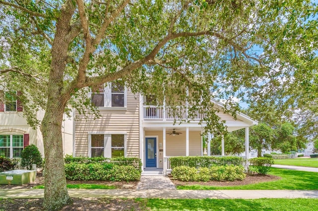 view of front of home featuring ceiling fan, a balcony, covered porch, and a front yard