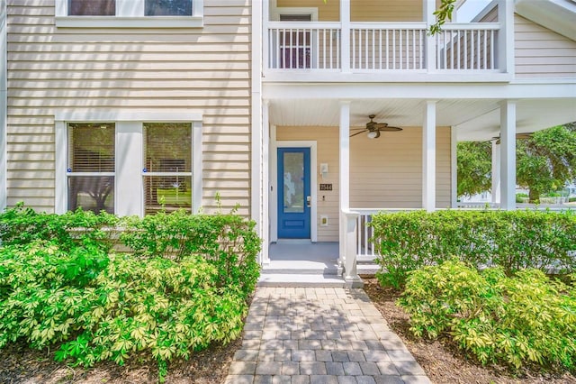 doorway to property with covered porch, ceiling fan, and a balcony