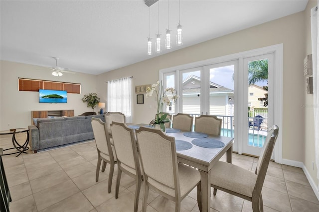 tiled dining area with ceiling fan and plenty of natural light