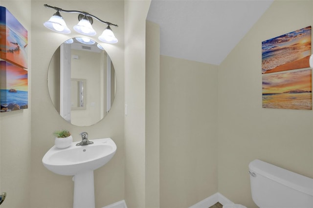 bathroom featuring vaulted ceiling and toilet